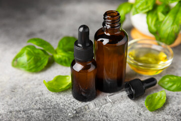Basil essential oil on a textured wooden background. Basil essential oil and fresh leaves. Aromatherapy. Aroma oil. Medical herbs. Alternative medicine. Place for text. Copy space.