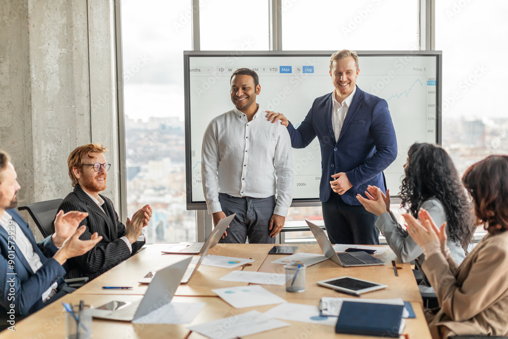 Poster a group of professionals in a modern office setting are applauding a presenter, who is standing in f