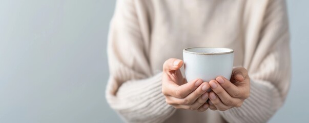 A cozy scene featuring a person holding a simple white mug, perfect for conveying warmth and comfort in everyday moments.