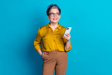 Photo of charming positive woman wear blue blouse eyeglasses texting instagram twitter telegram facebook isolated blue color background