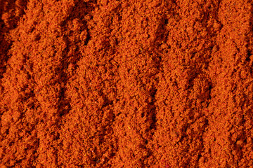 Ground paprika, red terracotta spice background, art in cooking.