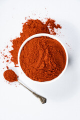 Spice ground smoked paprika on a white background.