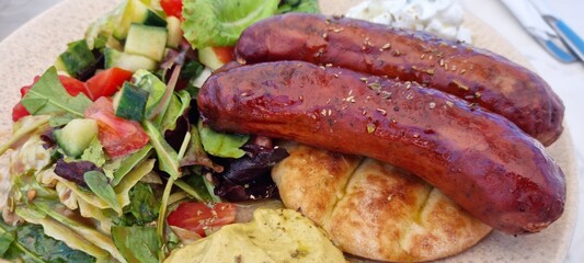 traditional greek dish with sausage, pure, vegetables and bread