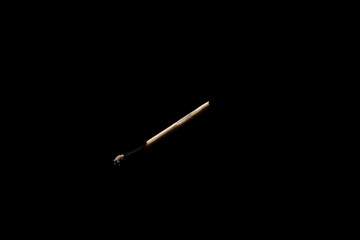 Lit falling match on a black background.