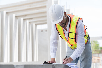 Male engineer construction working at construction site. Male engineer builder wear white helmet working at construction site