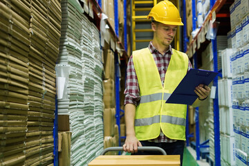 Warehouse worker wear safety equipment inspect and check goods package shelf in storage for supply import export logistic delivery