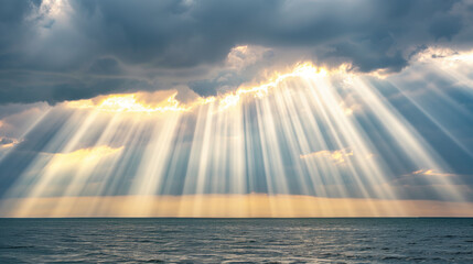 Dramatic sunbeams pierce through thick clouds, illuminating the ocean below with a stunning natural light display