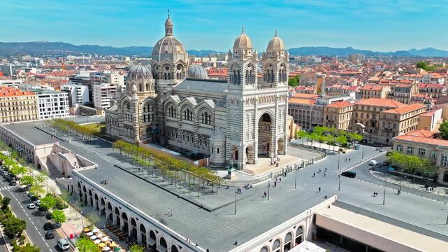 Aerial view of Byzantine cathedral with a striped facade, coloured stones, ornate domes and cupolas in Marseille. Cath&eacute;drale La Major features an opulent interior lined with murals and marble.
