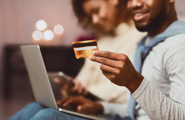 Online payment. Young couple using laptop and credit card, preparing for holidays