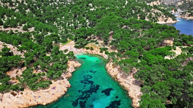 Aerial view of Natural area with rock formations, turquoise water beach in France. Calanque de Port Pin beach in the eastern calanque between Marseille and Cassis.
