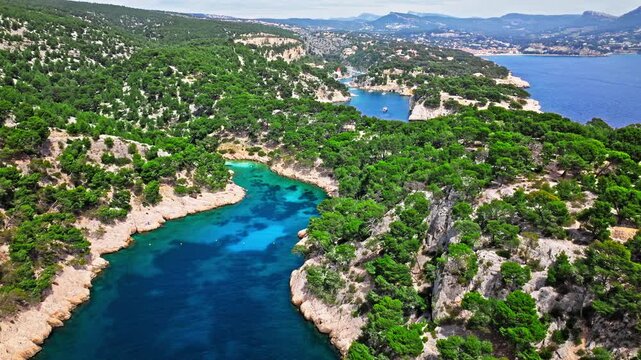 Aerial view of Natural area with rock formations, turquoise water beach in France. Calanque de Port Pin beach in the eastern calanque between Marseille and Cassis.
