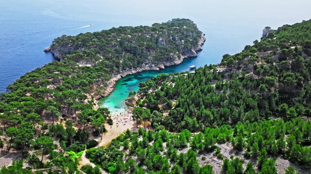 Aerial view of Natural area with rock formations, turquoise water beach in France. Calanque de Port Pin beach in the eastern calanque between Marseille and Cassis.
