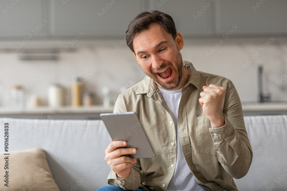 Aufkleber a man sits on a couch, holding a tablet in his hands and reacting with excitement. his mouth is open