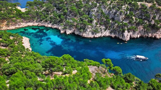Aerial view of Natural area with rock formations, turquoise water beach in France. Calanque de Port Pin beach in the eastern calanque between Marseille and Cassis.
