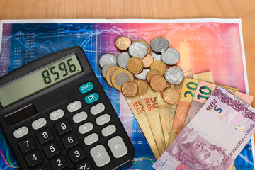 Brazilian money and a calculator  on  financial graph