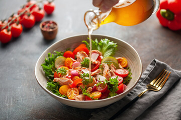 Salad with grilled salmon, fresh green  leaves, cucumber, tomatoes, sweet pepper and radish. Healthy lunch salad in bowl.
