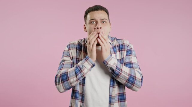 African american man rubs eyes, peers more closely smiling to camera on pink