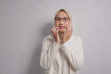 A Woman Wearing a White Blazer and Headscarf Expresses Fear