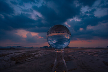 The moving clouds obscure the setting sun inside crystal ball. the sun moving down to the islands at Tubkaek beach Krabi. Nature High quality footage in nature and travel concept..