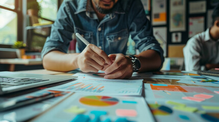 Creative professional using digital pen for concept development in busy office environment