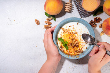 Frozen Shaved Peaches and Cream Dessert, Healthy summer snack with cream or yogurt and shaver frozen peach fruits, with nuts, honey and mint, copy space