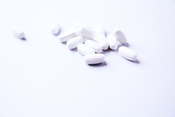 Amino acids tablets. Nutrition for bodybuilding. Fitness supplements on bright paper background. Soft focus. Copy space.	