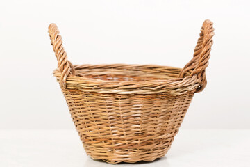 Obraz premium Empty wicker basket with two handles, low angle shot