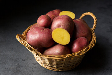 New potatoes in a wicker basket on a dark background