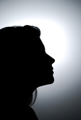 A stunning profile of a female silhouette in a close-up with a studio light.