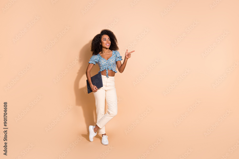 Sticker Full length photo of charming positive woman wear blue top holding modern device pointing empty space isolated beige color background