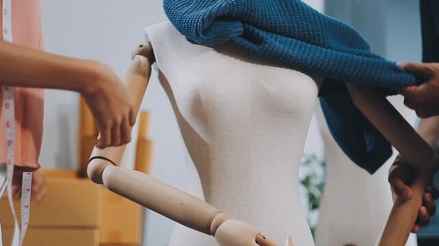 Designer concept.The dressmaker is designing an evening dress in the room.Asian clothing designers are measuring sample sizes to prepare evening gowns for important customer orders