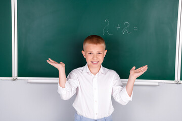Photo of clever smart nice boy solve mathematical task isolated on green board background