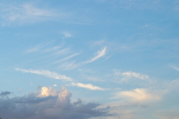 Cirrus and cumulus clouds illuminated by the sunset rays