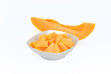 Slices of a melon in a white bowl isolated on white background.