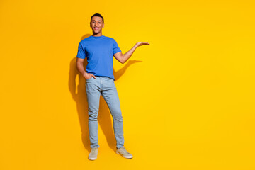 Fototapeta premium Full size photo of pretty young male hold empty space wear trendy blue outfit isolated on yellow color background