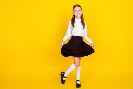 Full body photo of cute little schoolgirl show skirt fashion model dressed stylish uniform isolated on yellow color background
