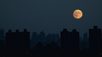 Urban nightscape with full moon. A bright, orange full moon illuminates the evening sky, casting an ethereal glow above the dark silhouettes of city buildings.