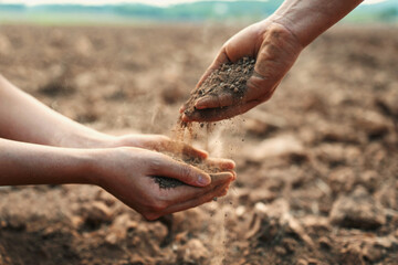 Two people are holding hands and throwing dirt at each other