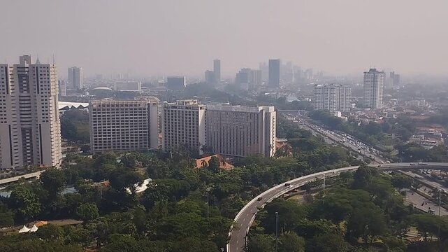 busy city amidst tall buildings, roads and passing vehicles