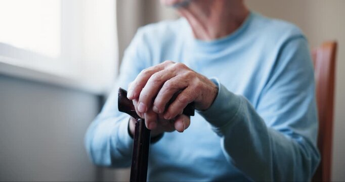 Balance, cane and hands with senior person in bedroom of retirement home to relax. Healthcare, support and walking stick with elderly resident in assisted living apartment for medical recovery