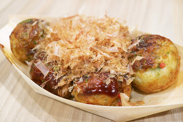 Japanese Takoyaki Octopus Balls, Topped with Sauce and Shaved Dried Bonito in a Boat Shaped Takeaway Bowl