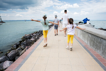 Family with children walking on a seaside pier enjoying a summer day in Siofok, Balaton lake, Hungary.