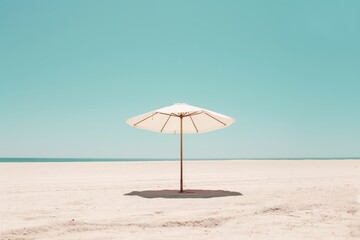 Single beach umbrella on empty sandy beach under clear sky