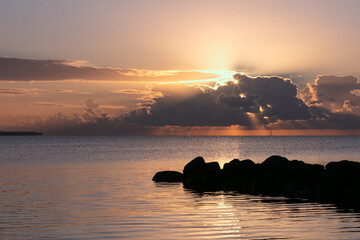 Rock pier with dramatic sky and sun breakthrough 