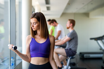 Fototapeta premium Fitness woman. Fit fitness girl smiling happy lifting weights looking strength training muscles.