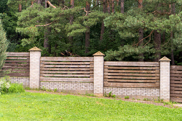 Wooden stone fence near a pine forest