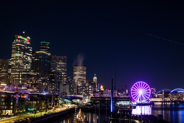 Vibrant City Skyline with Illuminated Ferris Wheel at Night