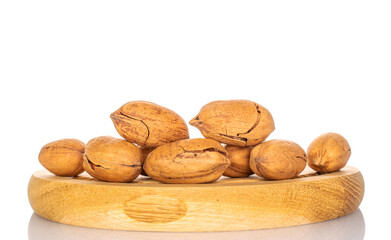Several unshelled pecans on a wooden tray, macro, isolated on white background.