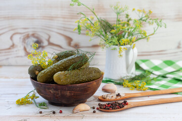 Bowl of tasty pickled cucumbers with spices and dill on light background. Marinated homemade pickled cucumbers. Healthy fermented food