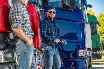 Men Discussing Trucks at a Transportation Yard on a Sunny Day